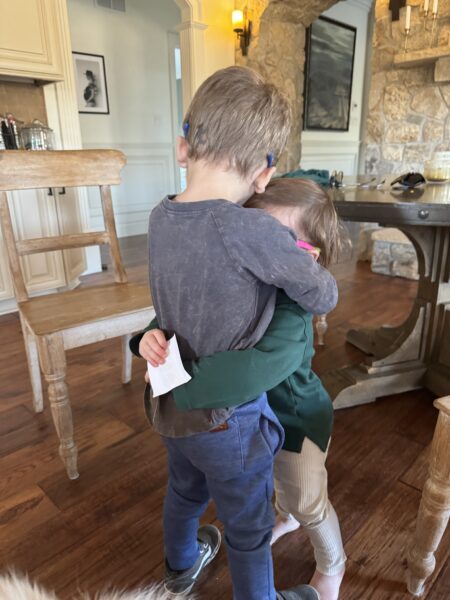 toddler siblings hugging